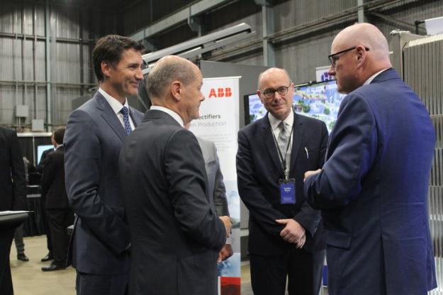 Den kanadiske statsministeren Justin Trudeau og Tysklands kansler Olaf Scholz diskuterer betydningen av grønn hydrogenproduksjon for de to landenes økonomiske og energimessige fremtid. På sin side forklarer ABB Process Industries-president Joachim Braun og Hydrogen Optimized CEO Andrew Stuart hvordan ABB høyeffekts likerettere støtter Hydrogen Optimizeds RuggedCell-teknologi ved å bruke vindkraft til å produsere hydrogen i stor skala. Lederne møttes på den tysk-kanadiske Atlantic Renewable Hydrogen Expo i Stephenville, Newfoundland 23. august.